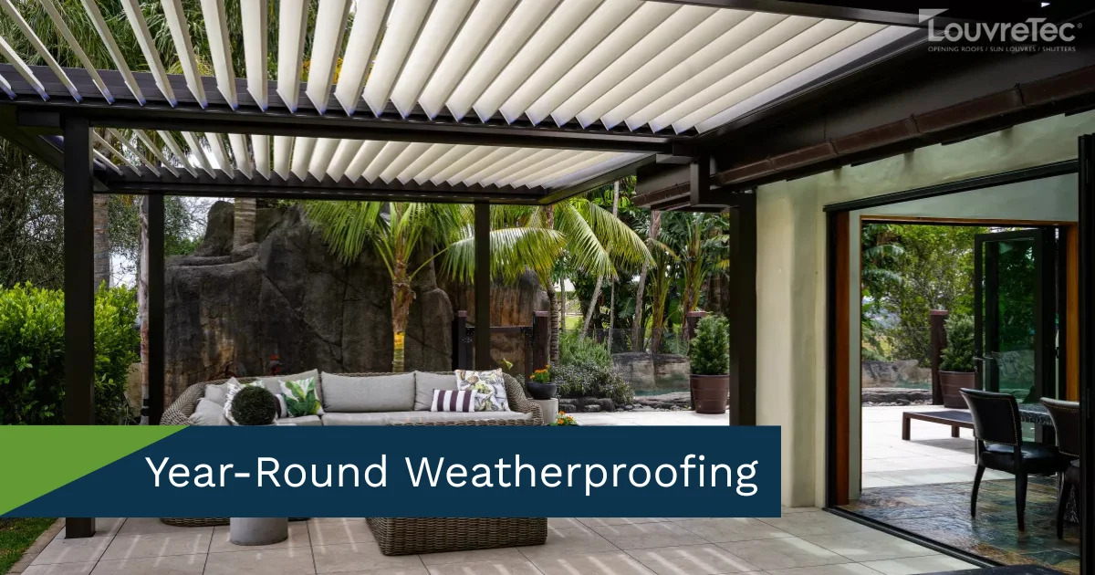 Modern home with a Louvretec opening roof over a patio, surrounded by lush plants.