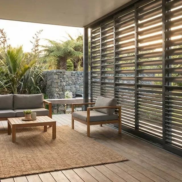 Covered outdoor patio with adjustable louvres that provide shade, privacy and natural ventilation, showing practical uses of louvres for weather control and comfort.
